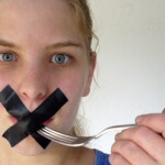 A staged image, originally made for an article I wrote Woman with mouth taped shut, refusing entry to fork